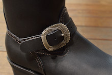 Silver 925を使ったインディアンの羽飾り（ウォーボンネット）をモチーフにした緻密なデザインのオリジナルバックルがブーツの顔となっている。