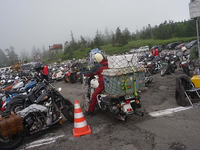 キャンプ道具をバイクに括り付け、全国から参加者がやってくる。山の麓では晴れていても、山頂は雨ということも多い。