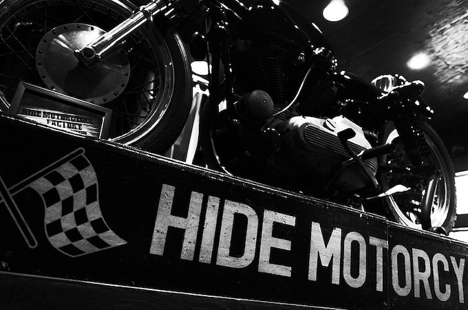 SHOP“RUDIE'S KASUKABE” の中央に、HIDE MOTORCYCLE×RUDE GALLERYのコラボマシン、漆黒のアイアンチョッパーが展示されている。