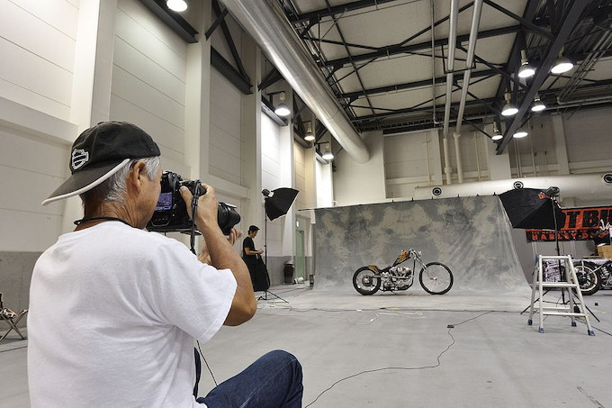 コチラも恒例の雑誌ホットバイクジャパンによる出展車両の全台撮影の様子。HBJ.comでコラムを連載頂いている磯部カメラマン渾身の写真はHBJ140号で！